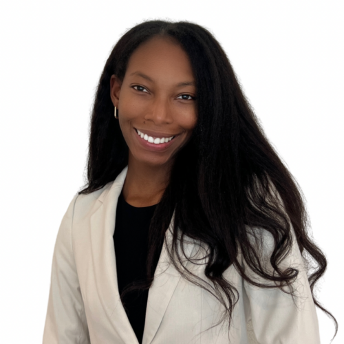 Smiling Black woman with long black hair, wearing a beige blazer and black top against a white background.