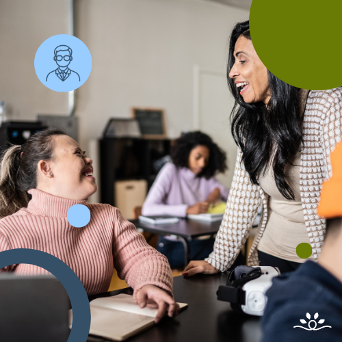A classroom scene where a woman in a beige cardigan leans toward a young woman in a pink ribbed turtleneck sweater, who is smiling and seated at a desk with a laptop. Two students in the background work independently. Circular overlays in green and blue accent the corners. Upper left contains a white faculty icon inside a blue circle. NDCSS logo bottom right.